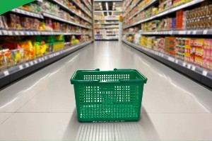 Empty green grocery basket in center of stocked shelves in grocery store aisle
