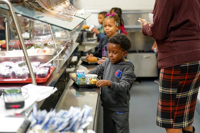 Young boy going through lunch line in a school cafeteria with his tray